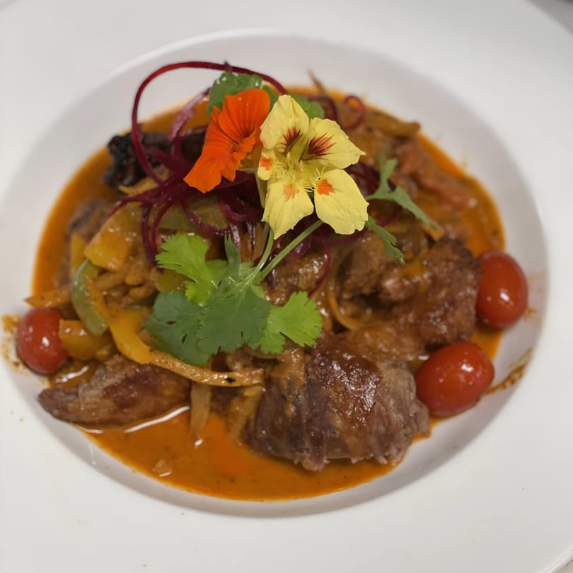 Saisaki Van Wert's Japanese dish with meat, vegetables, cherry tomatoes, and edible flowers.