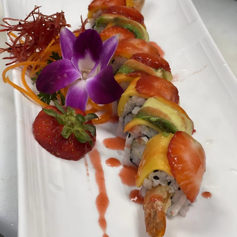 Saisaki Van Wert's colorful sushi roll with mango, avocado, and strawberry, garnished with an orchid.